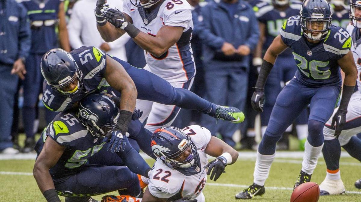 
Seahawks defensive lineman Frank Clark forces Broncos running back C.J. Anderson to fumble, but Denver recovers it in the first quarter of an NFL preseason football game between Seattle and Denver at Century Link Field in Seattle, August 14, 2015.
