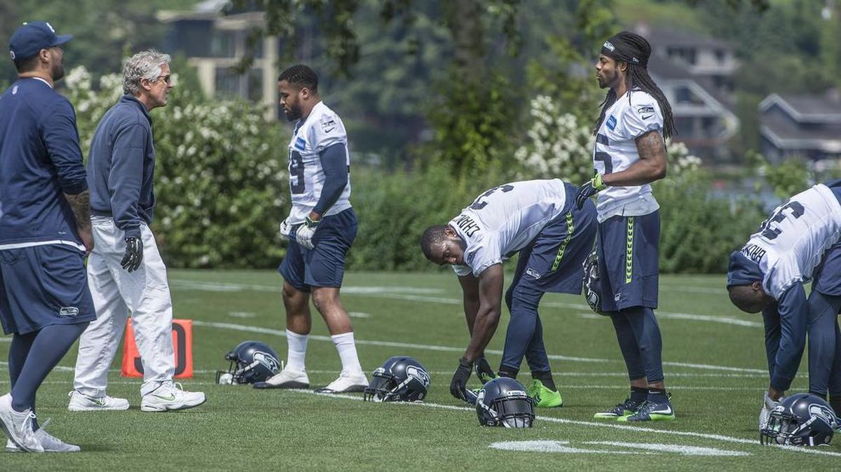 Coach Pete Carroll talks to the original members of the Seahawks’ “Legion of Boom” secondary -- in white from left Earl Thomas, Kam Chancellor, Richard Sherman and Brandon Browner -- this week at the team’s organized team activities in Renton.