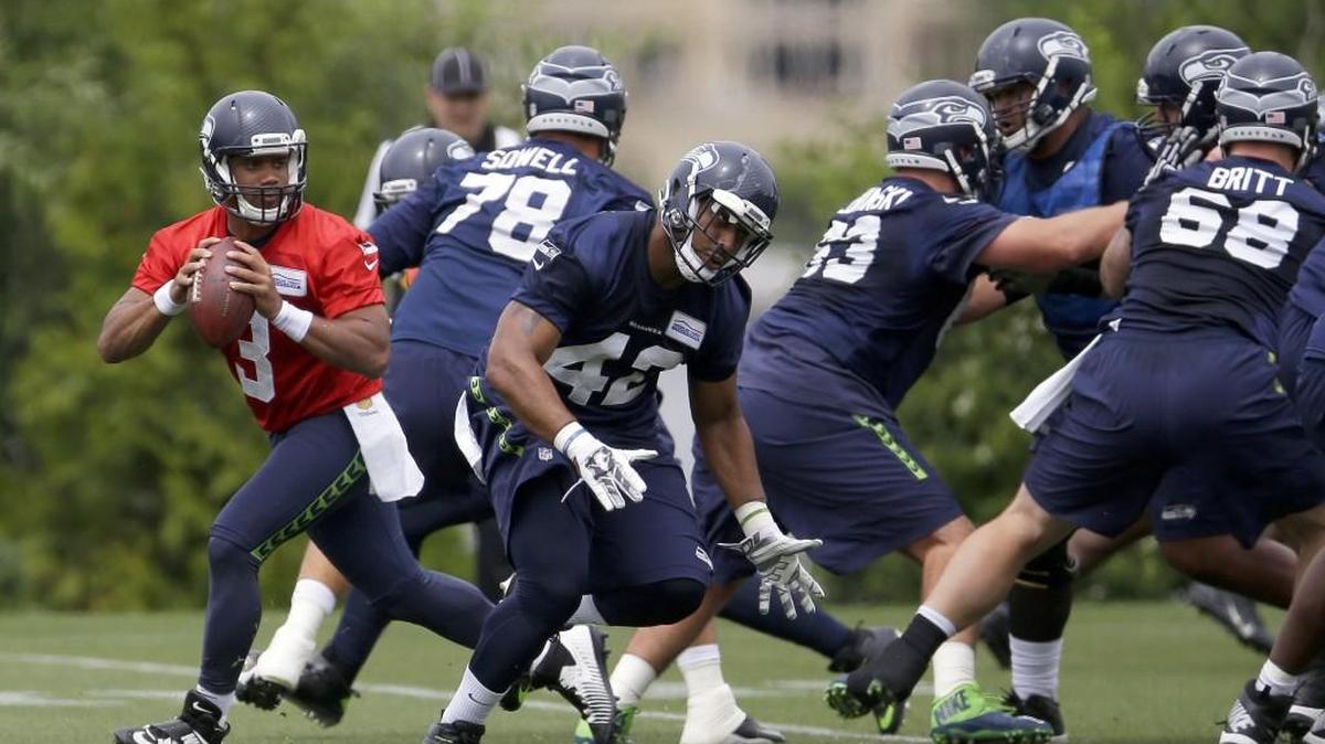 Seattle quarterback Russell Wilson, left, drops to pass during practice, Thursday in Renton.