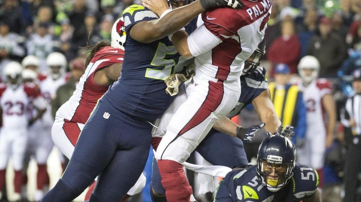 Seahawks defensive lineman Cliff Avril hits Cardinals quarterback Carson Palmer during Sunday night's NFL football game at CenturyLink Field in Seattle on Nov. 15, 2015.