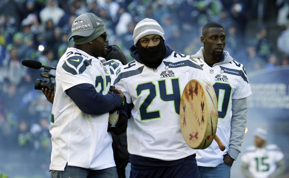 Seattle Seahawks running back Marshawn Lynch (24) carries a drum as he walks on the field with running back Robert Turbin, left, and cornerback Jeremy Lane, right, during a celebration Wednesday, Feb. 5, 2014, at CenturyLink Field in Seattle. The Seattle Seahawks beat the Denver Broncos last Sunday in the NFL Super Bowl XLVIII football game in East Rutherford, N.J. (AP Photo/Ted S. Warren)
