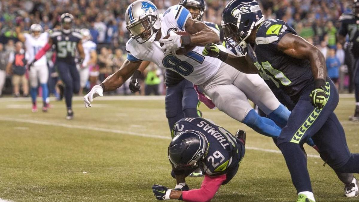As Lions receiver Calvin Johnson stretches for the end zone, Seahawks safety Kam Chancellor prepares to punch the ball loose in the waning moments of the fourth quarter. Photo taken in Seattle on Monday, Oct. 5, 2015.