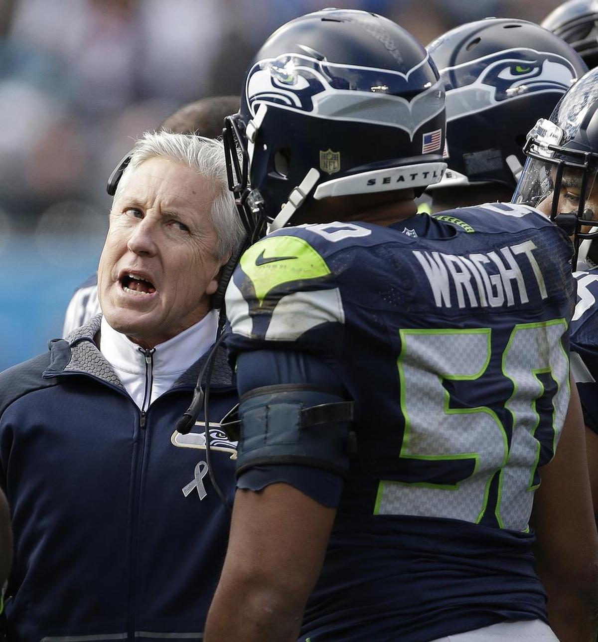 Seattle Seahawks head coach Pete Carroll speaks with Seattle Seahawks outside linebacker K.J. Wright (50) on the sidelines during the first half of an NFL divisional playoff football game against the Carolina Panthers, Sunday, Jan. 17, 2016, in Charlotte, N.C. (AP Photo/Bob Leverone)