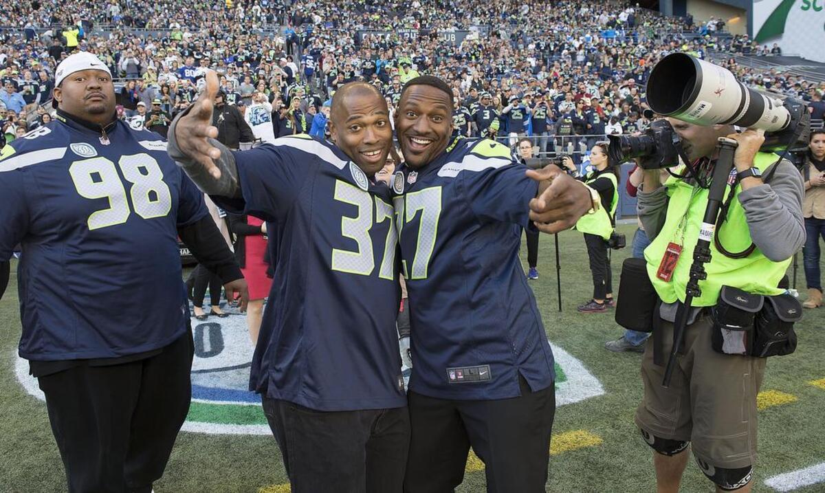 Former Seattle running back Shaun Alexander, left, and safety Jordan Babineaux ham it up prior to the ceremony celebrating Seahawks Legends. Photo taken in Seattle on Sunday, Sept. 27, 2015.