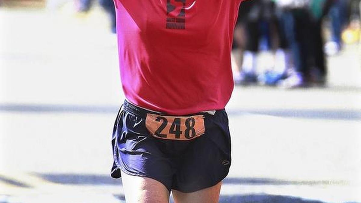 Women’s division winer Linda Huyck celebrates as she nears the finish line at the 2015 Capital City Marathon in Olympia.