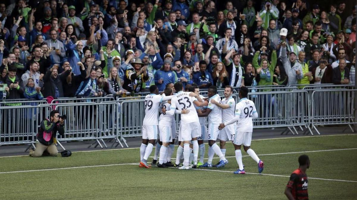 Sounders players surround midfielder Zach Mathers and celebrate in front of fans after Mathers scored the go-ahead goal against the Portland Timbers during the second half of a U.S. Open Cup soccer match Tuesday at Starfire Stadium.