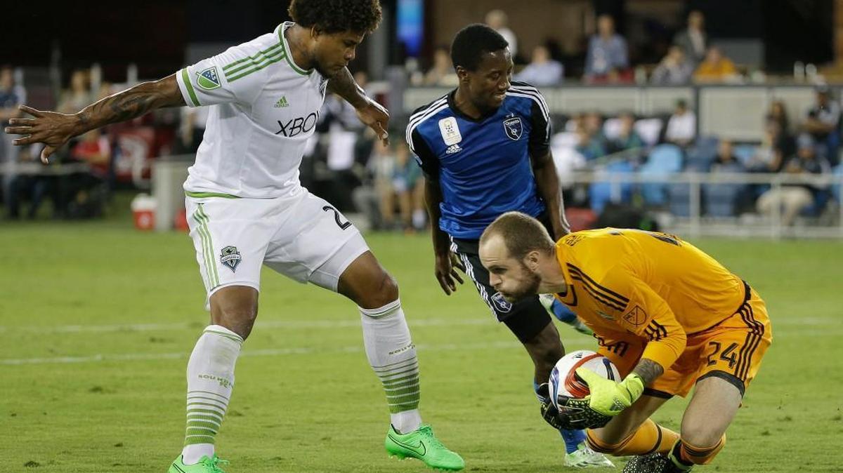 
Seattle Sounders goalkeeper Stefan Frei, right, grabs the ball in front of teammate Roman Torres, left, and San Jose Earthquakes midfielder Cordell Cato.
