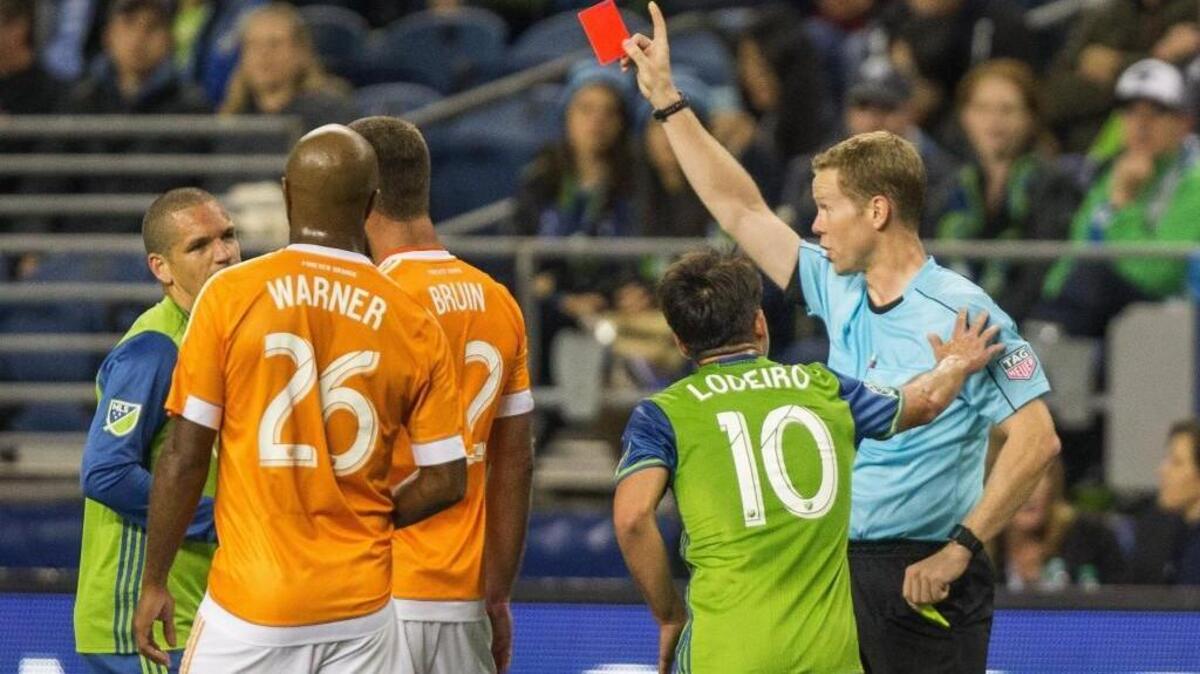 Seattle midfielder Osvaldo Alonso, left, receives a red card from referee Drew Fischer during the Sounders’ 0-0 draw against Houston on Wednesday.