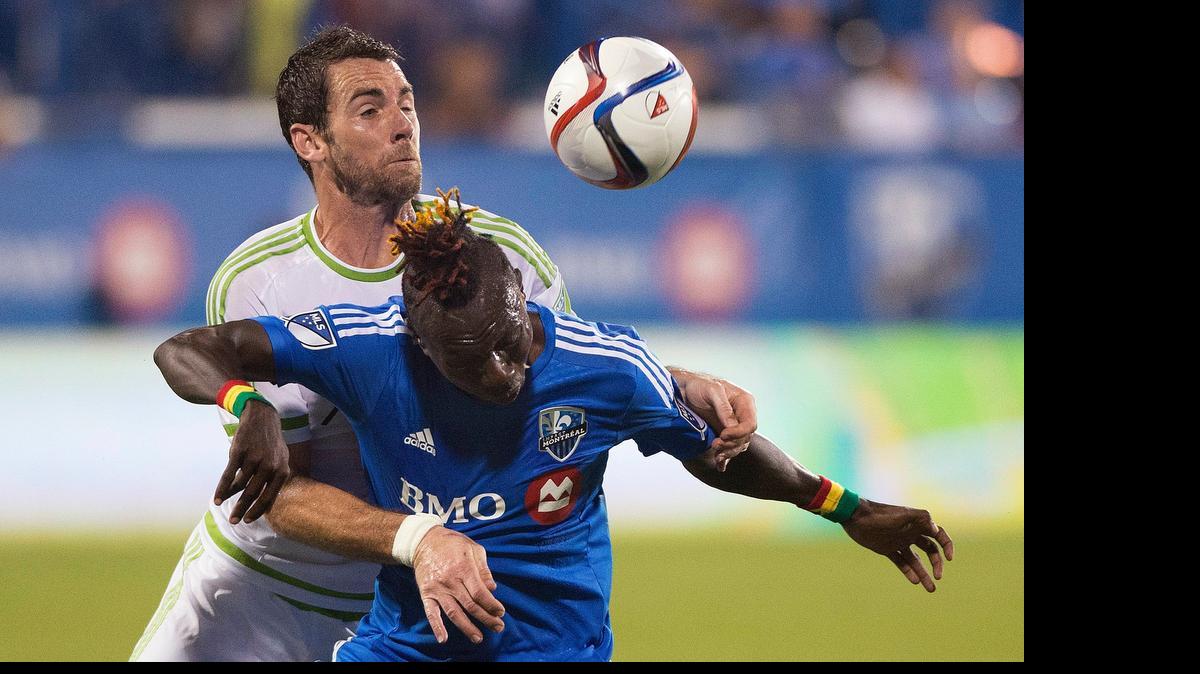 
Seattle’s Zach Scott, top, battles Dominic Oduro of the Impact during the second half Saturday in Montreal.
