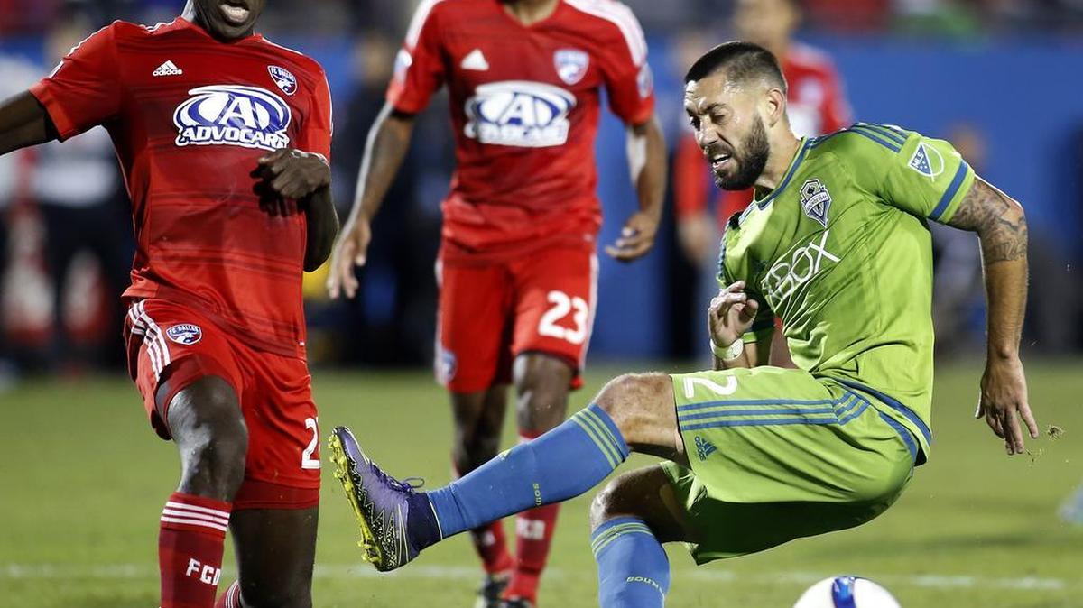 Sounders forward Clint Dempsey’s shot is blocked by FC Dallas defender Je-Vaughn Watson, left, Sunday during their match in Frisco, Texas.