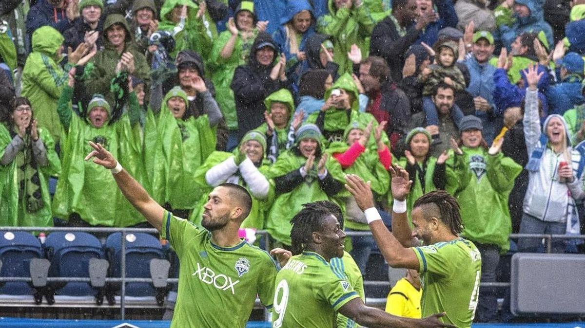 Sounders star Clint Dempsey, left, acknowledges the crowd after his second goal on a second assist assist from teammate Obafemi Martins, center, to give Seattle a 3-0 first half lead in the Oct. 25 regular-season finale vs. Real Salt Lake, with a playoff berth on the line.