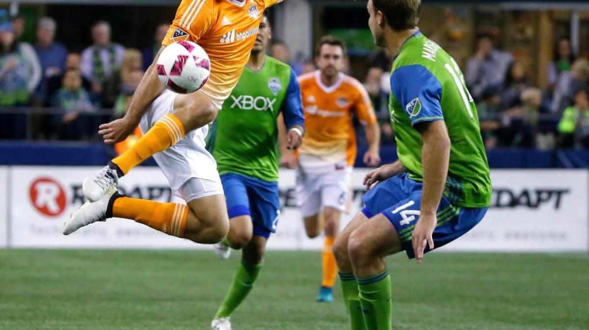 Houston Dynamo forward Will Bruin, left, leaps to make a kick against Seattle Sounders defender Chad Marshall, right, during a 2016 match in Seattle. The Sounders traded for Bruin in the offseason to add depth to their front line.