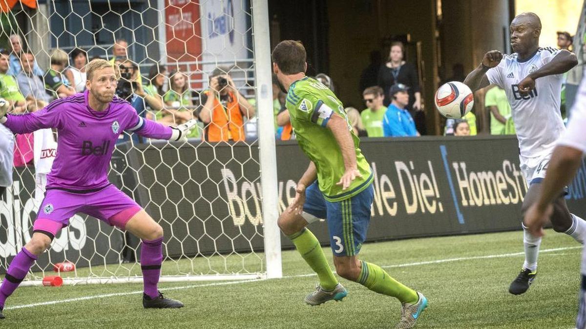 
Vancouver's Pa-Modou Kah, right,appears to hit his elbow on the soccer ball on a Sounders corner kick near Seattle’s Brad Evans at CenturyLink Field on Saturday night.
