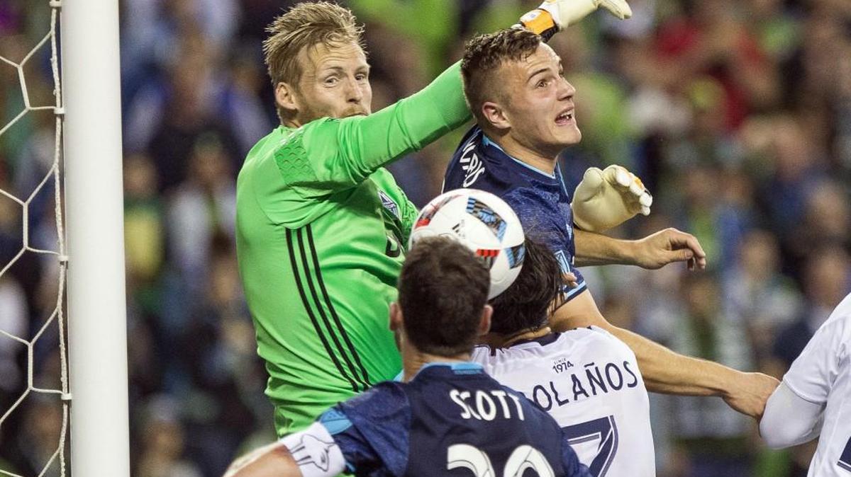 The Sounders get a good look at goal off the corner kick in the first half, but Jordan Morris, right, can't get position on the ball, punched away by Vancouver Whitecaps keeper David Ousted, left, on Saturday at CenturyLink Field in Seattle.