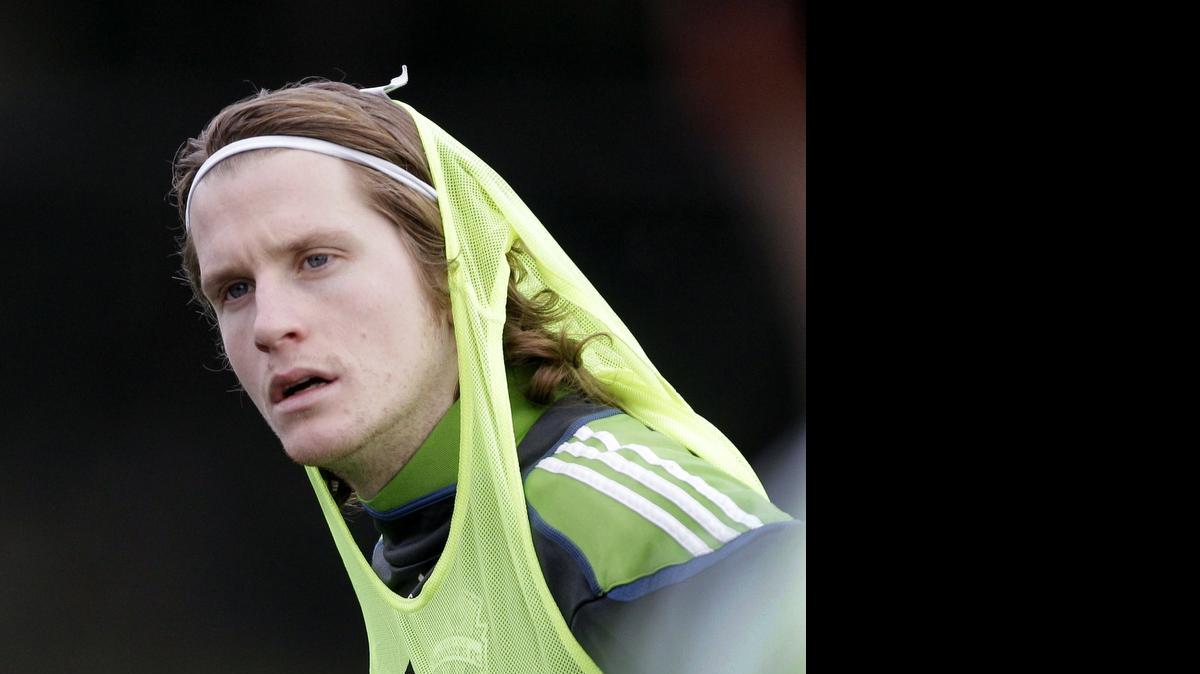 
Seattle Sounders' Erik Friberg, of Sweden, pulls a pinnie over his jersey during the team's first day of MLS soccer training camp in 2011. Friberg re-signed with the Sounders on June 27.
