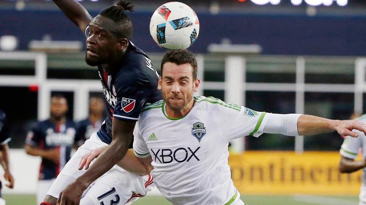 New England Revolution's Kei Kamara (13) battles Seattle Sounders' Zach Scott for the ball during the first half of an MLS soccer game, Saturday, May 28, 2016, in Foxborough, Mass.