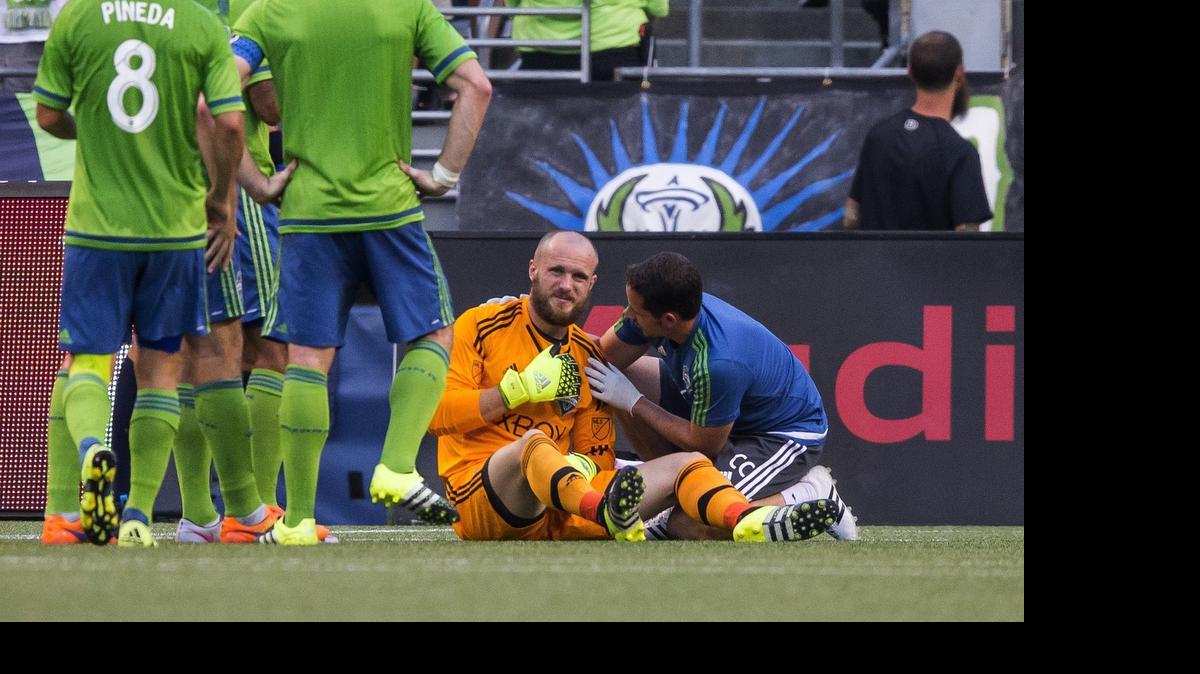 
A trainer looks at the shoulder of Seattle Sounders goalkeeper Stefan Frei, who was injured in a collision in the first half against DC United on Friday, July 3, 2015, at CenturyLink Field in Seattle.

