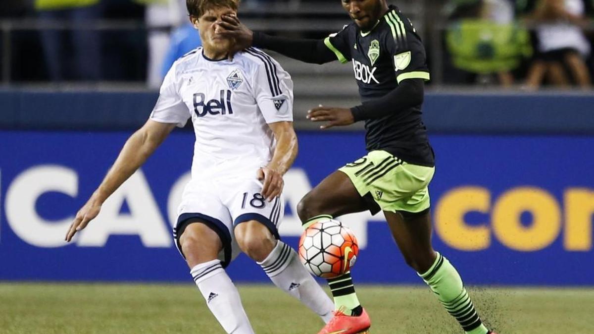 
Vancouver Whitecaps defender Diego Rodriguez, left, gets a hand to the face from Seattle Sounders defender Oniel Fisher during the second half of a CONCACAF Champions League match Wednesday at CenturyLink Field in Seattle.
