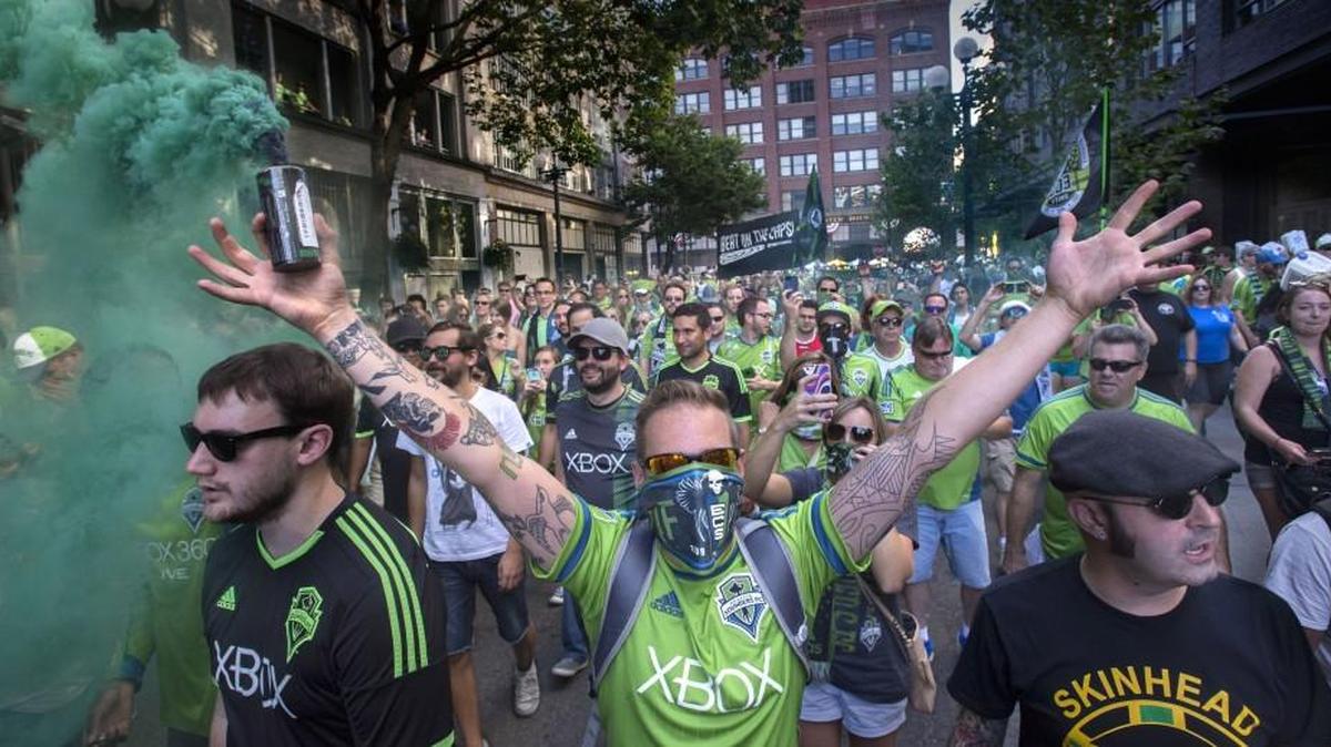Seattle Sounders fans march down Occidental Avenue South to CenturyLink Field before the start of a game with Vancouver Whitecaps last season.