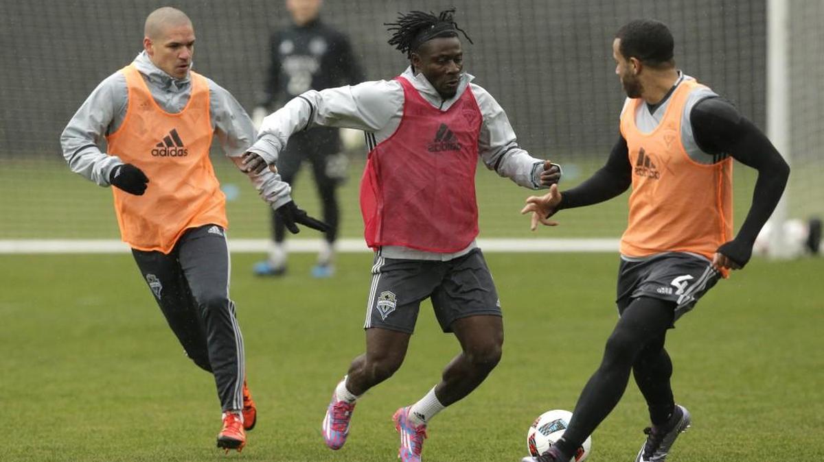 Osvaldo Alonso, left, in training with teammates Obafemi Martins and Tyrone Mears, right, in Tukwila.
