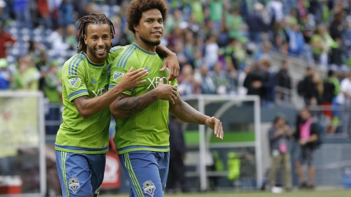 
Sounders' Roman Torres, right, with teammate Tyrone Mears during Sounders game with Portland in August.
