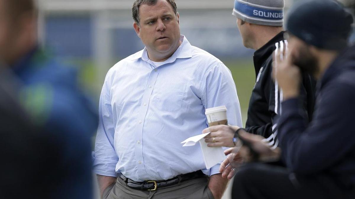 Garth Lagerwey, center, the new general manager of the Seattle Sounders MLS soccer team, talks on the sideline as he observes a training session last February.