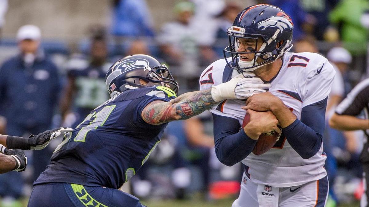 
Seahawks defensive lineman Cassius Marsh grabs Broncos quarterback Brock Osweiler on Friday.

