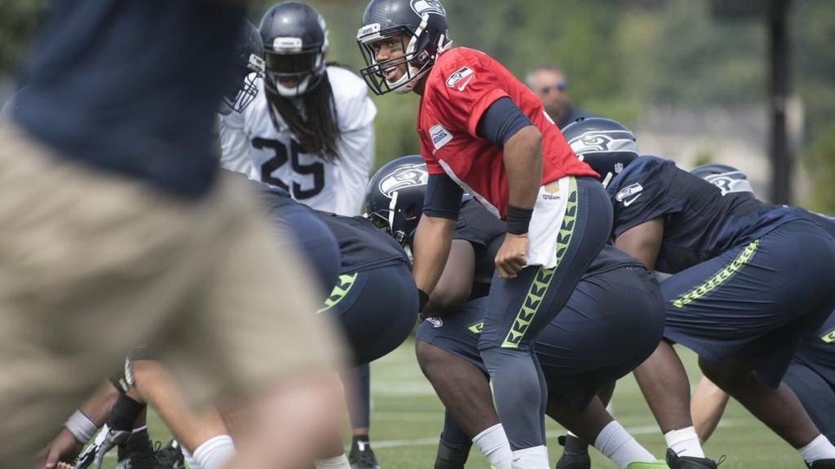 Seahawks quarterback Russell Wilson directs the offense Saturday during the opening of training camp in Renton. “I’m always motivated,” says Wilson, who got married to R&B singer Ciara during the offseason. “I’m always motivated to be the best in the world at playing quarterback.”