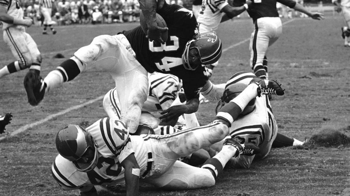Atlanta running back Junior Coffey (34) tramples a few Philadelphia Eagles on route to a first down in the first half of an NFL game at Atlanta, on Oct. 8, 1967.