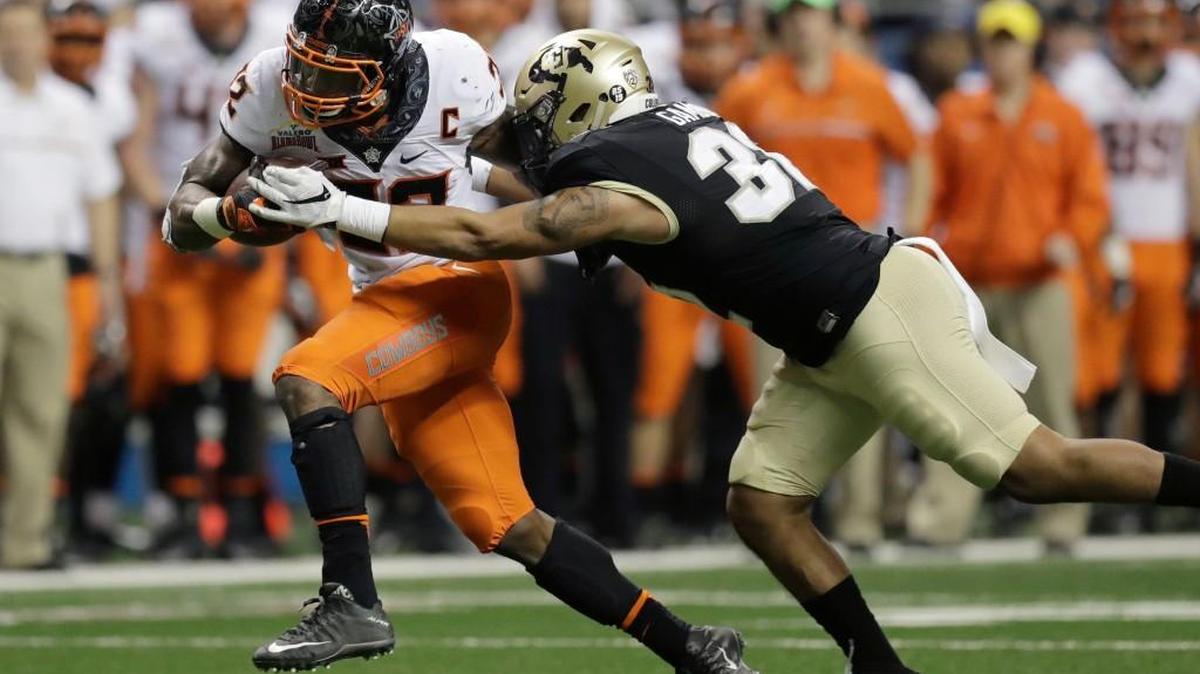 Oklahoma State running back Chris Carson, left, is hit by Colorado linebacker Rick Gamboa as he runs for a first down during the second half of the Alamo Bowl NCAA college football game, Thursday, Dec. 29, 2016, in San Antonio.
