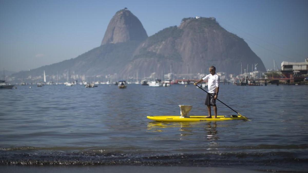 A protester paddles with a toilet atop his board during a demonstration on Botafogo Beach, in the Guanabara Bay in Rio de Janeiro in 2015, near where Olympic sailing events are to be held.