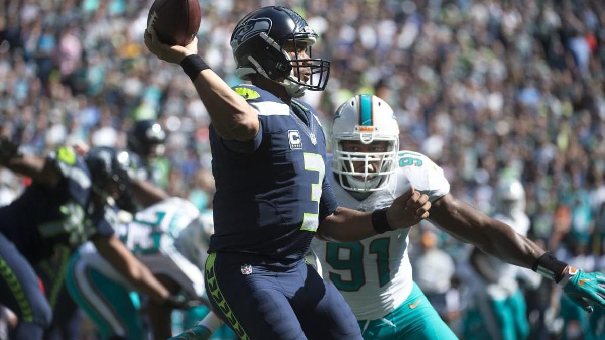 Seahawks quarterback Russell Wilson gets rid of the football under pressure from Dolphins defensive lineman Cameron Wake during Seattle’s the season-opening victory at CenturyLink Field.