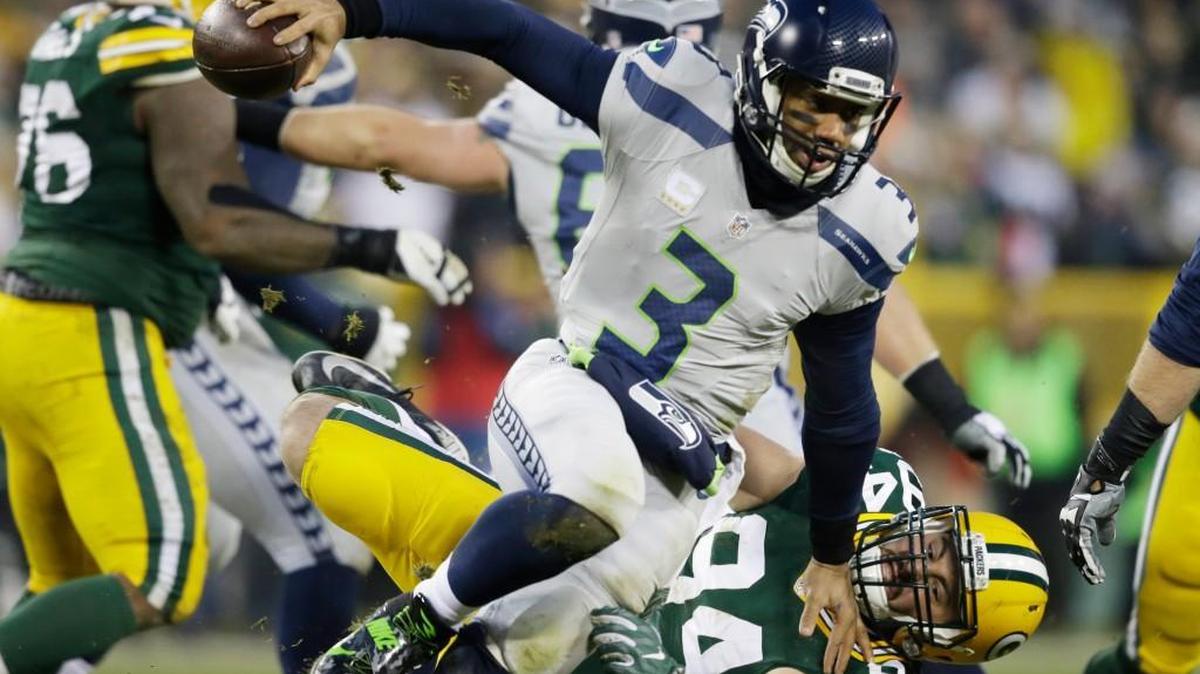 Green Bay defensive end Dean Lowry trips up Seattle quarterback Russell Wilson during the first half of the Seahawks’ 38-10 loss Sunday in Green Bay, Wis.