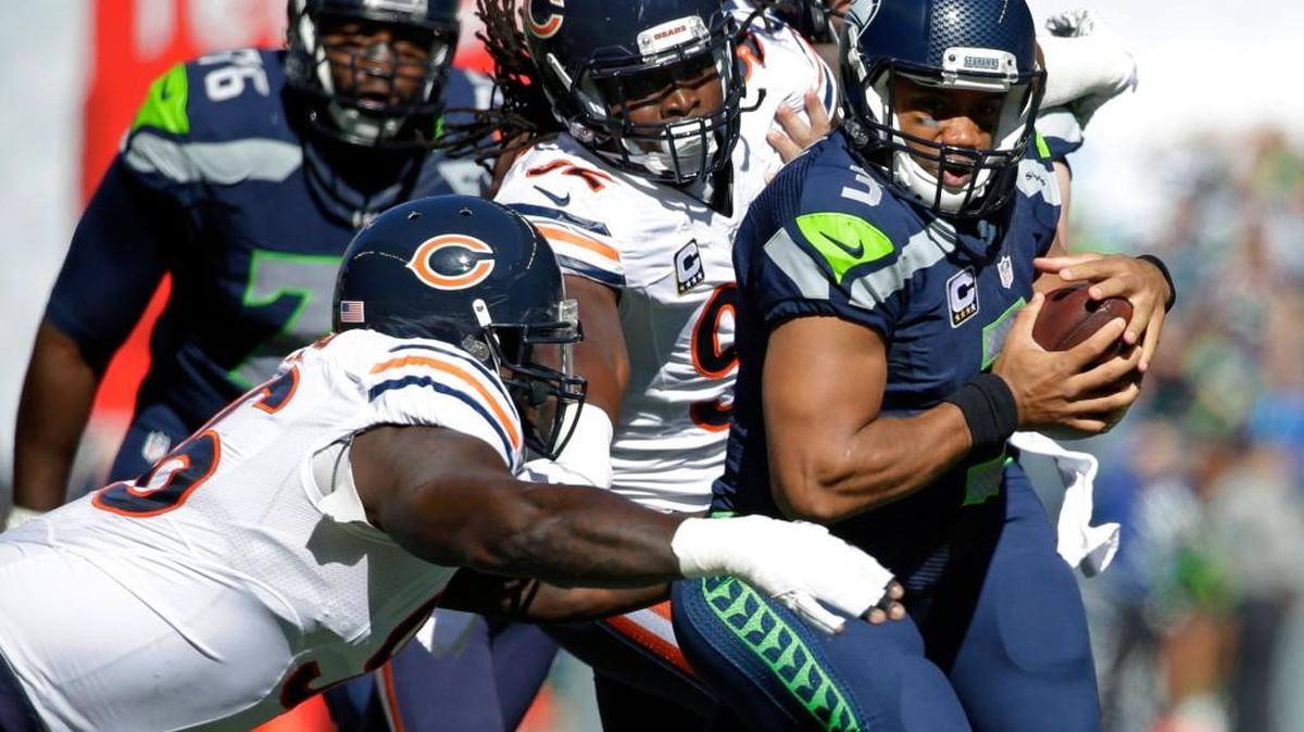 
Seattle Seahawks quarterback Russell Wilson, right, is tackled by Chicago Bears' Jarvis Jenkins, left, and Pernell McPhee, center, during the first half of an NFL football game, Sunday, Sept. 27, 2015, in Seattle.
