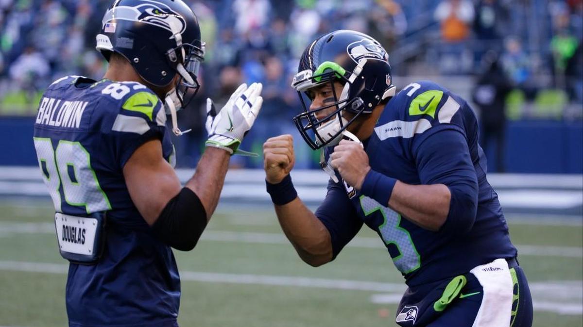 Seahawks quarterback Russell Wilson, right, and receiver Doug Baldwin feign boxing as they warm up Saturday.