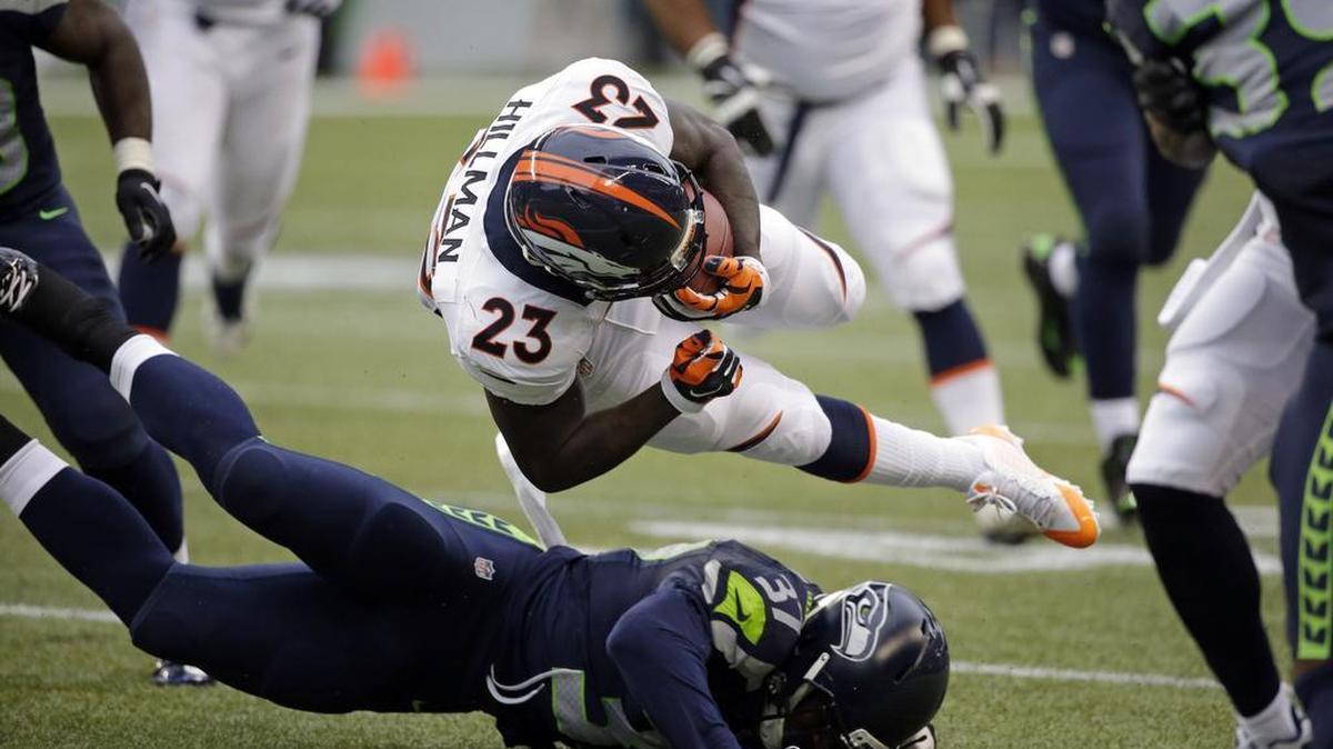 
Seattle Seahawks safety Dion Bailey, bottom, upends Denver running back Ronnie Hillman on Friday during the exhibition opener at CenturyLink Field in Seattle. Bailey credits teammates Earl Thomas and Kam Chancellor with helping him improve during his young career.
