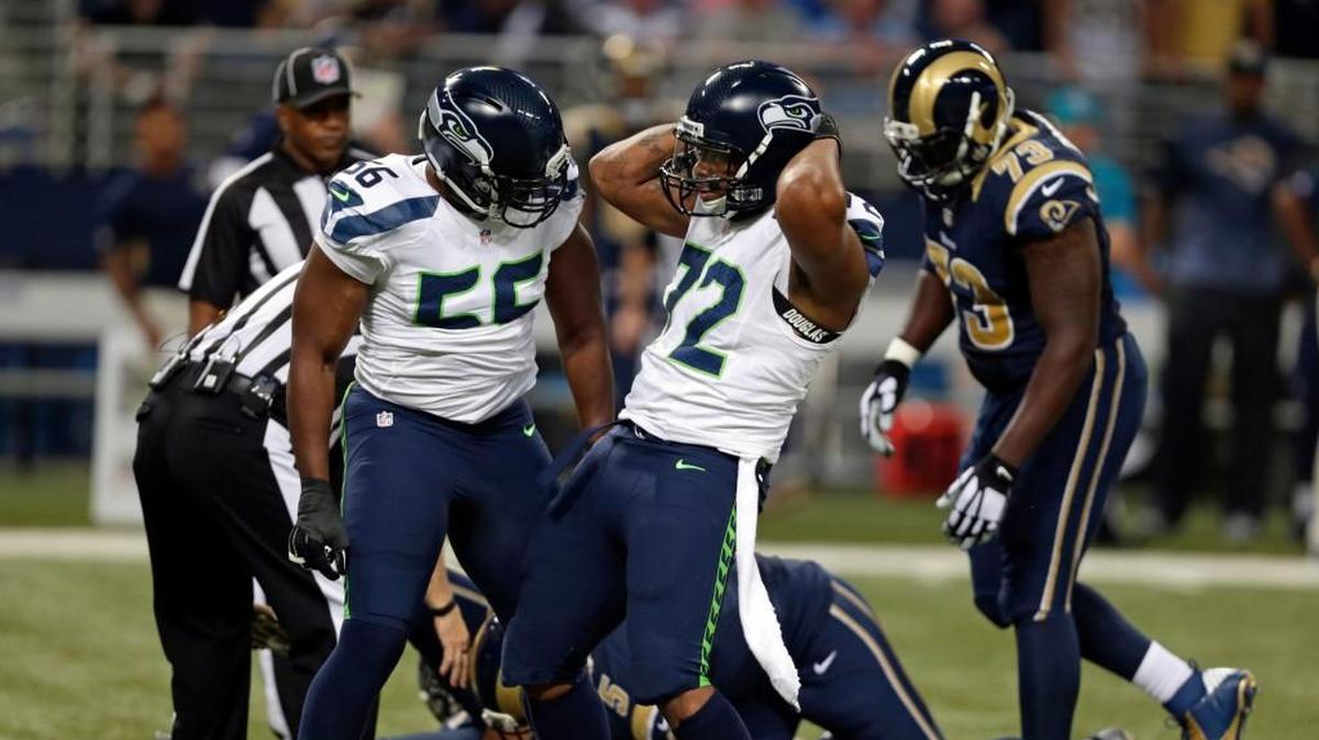 
Seahawks defensive end Michael Bennett, right, clebrates with teammate Cliff Avril after sacking Rams quarterback Nick Foles on Sunday.
