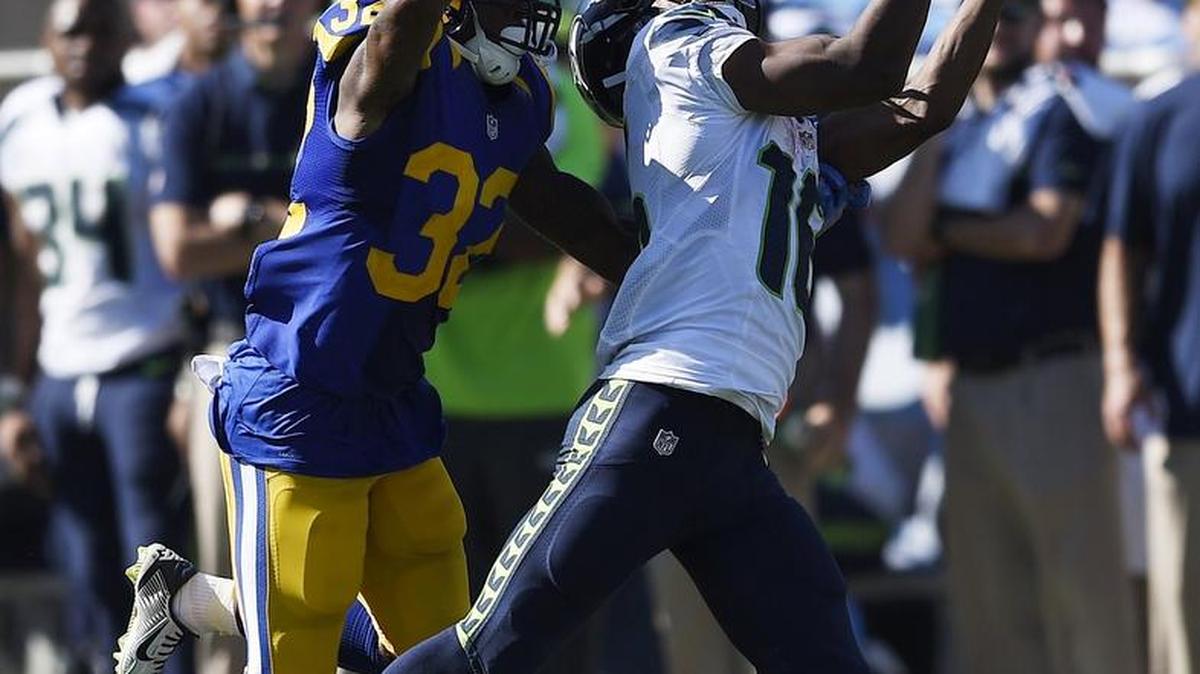 Seattle Seahawks wide receiver Tyler Lockett, right, makes a catch while under pressure from Rams cornerback Troy Hill. Lockett exited the game early due to a sprained knee, but he was able to return.