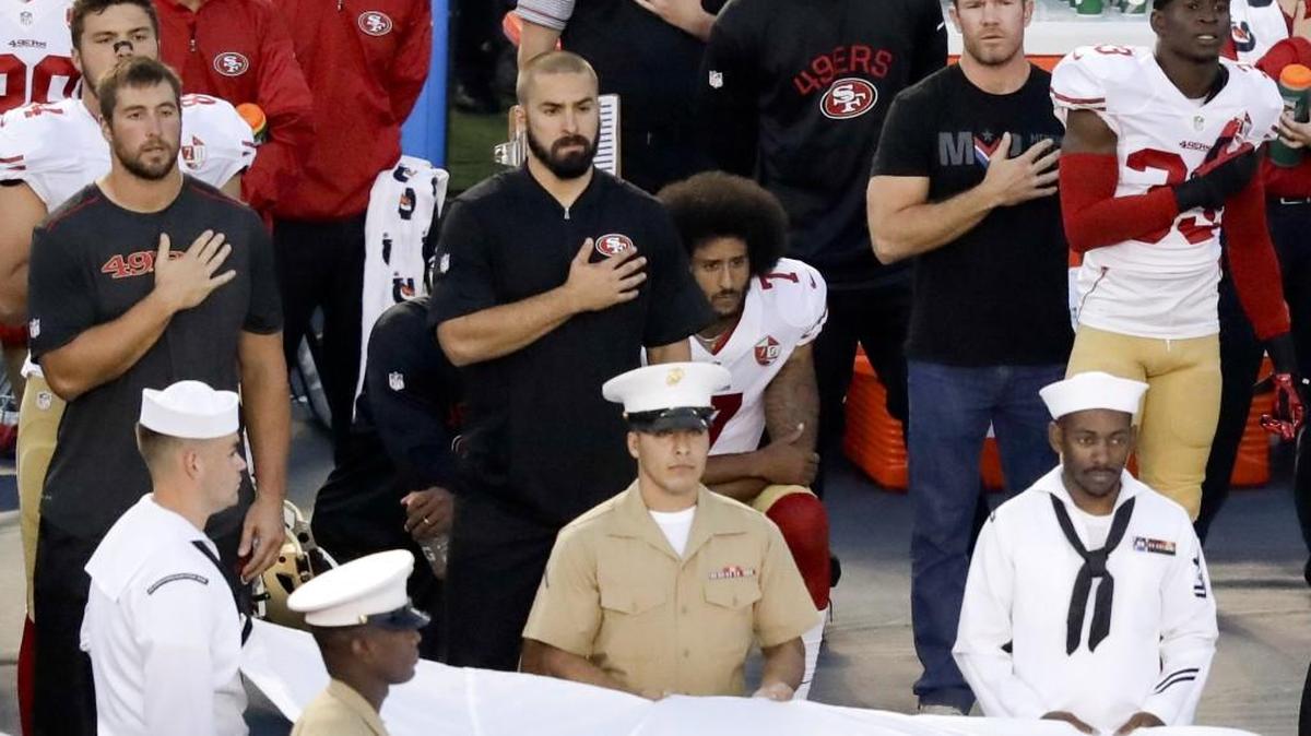 San Francisco 49ers quarterback Colin Kaepernick, middle, sits during the national anthem last Thursday. Ex-Green Beret and Seahawks long snapper Nate Boyer, second from right, penned an open letter to Kaepernick about his protest and met with him about it.