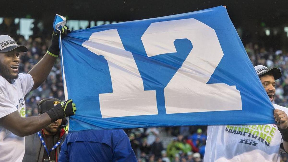 
Seahawks safety Kam Chancellor, left, and Russell Wilson hold up a 12th man flag at CenturyLink Field in Seattle in January following the team’s second straight NFC Championship victory. Chancellor had not yet reported to training camp Wednesday due to a contract dispute.
