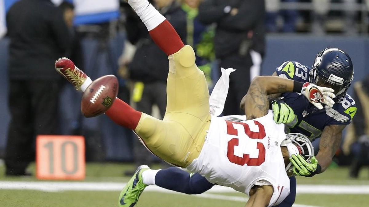 Seahawks receiver Ricardo Lockette (83) tackles the 49ers' LaMichael James (23) on a kickoff, forcing a fumble, during the first half of the NFL football NFC Championship Game Jan. 19, 2014.