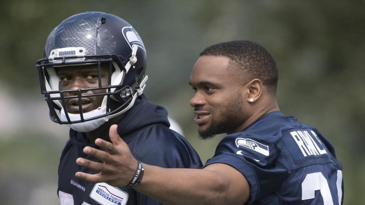 The Seattle Seahawks’ Christine Michael, left, listens to fellow running back Thomas Rawls during the opening day of training camp at the team's Virginia Mason Athletic Complex in Renton on Saturday.