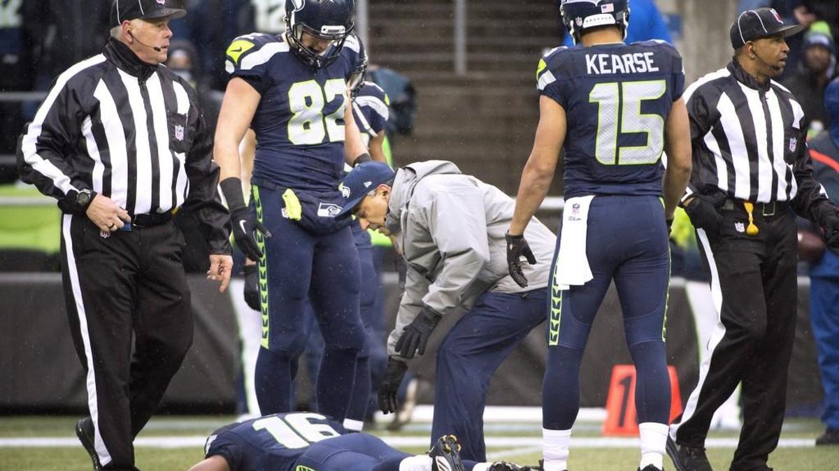 Team doctor checks on Seahawks wide receiver Tyler Lockett after he was hurt on a Rams interception during Sunday's NFL football game against the St. Louis Rams at CenturyLink Field in Seattle on Dec. 27, 2015. He left the game, but returned later.