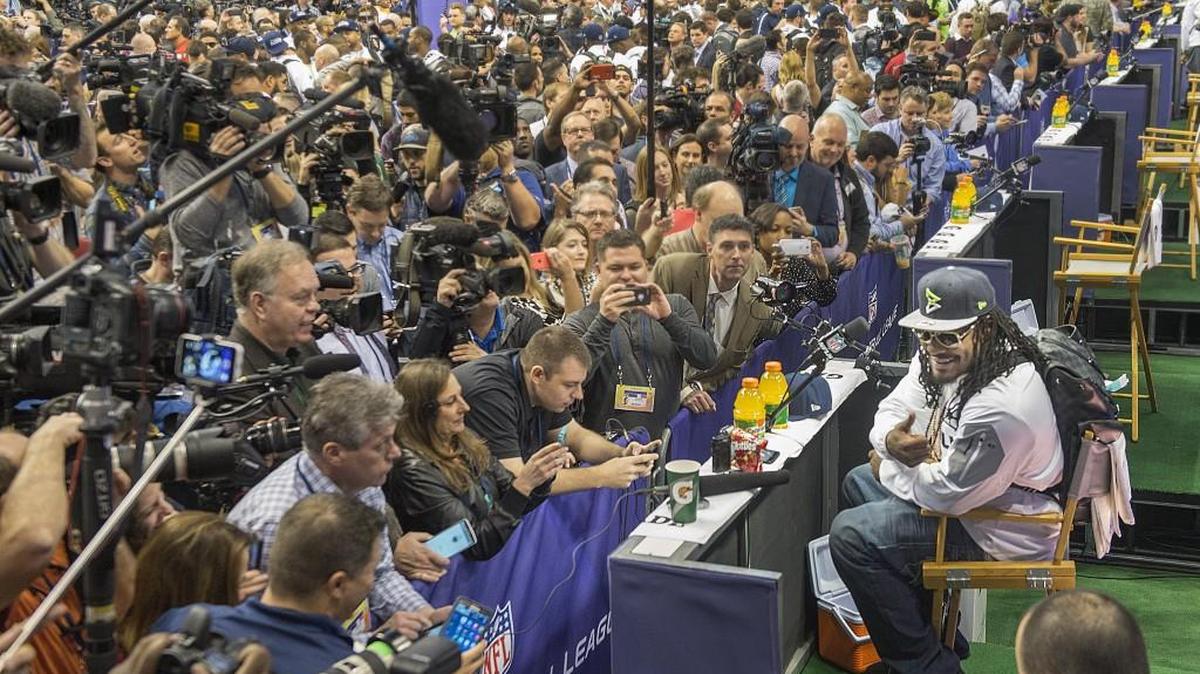 Seahawks running back Marshawn Lynch grins and offers a thumbs up for a photo in a brief required appearance at Media Day in Phoenix, Ariz., on Tuesday, Jan. 27, 2015.