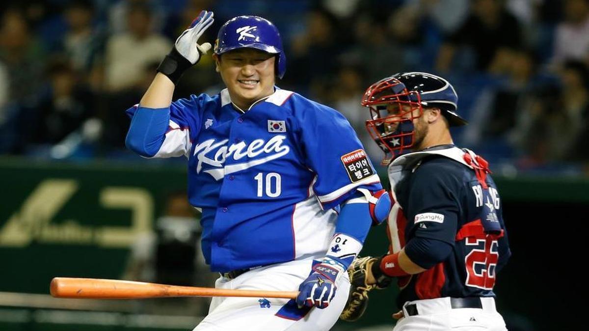 South Korea's designated hitter Lee Dae-ho (10) reacts after getting struck out in front of USA catcher Dan Rohlfing during the fourth inning of their final game at the Premier12 world baseball tournament at Tokyo Dome in Tokyo, Saturday, Nov. 21, 2015.