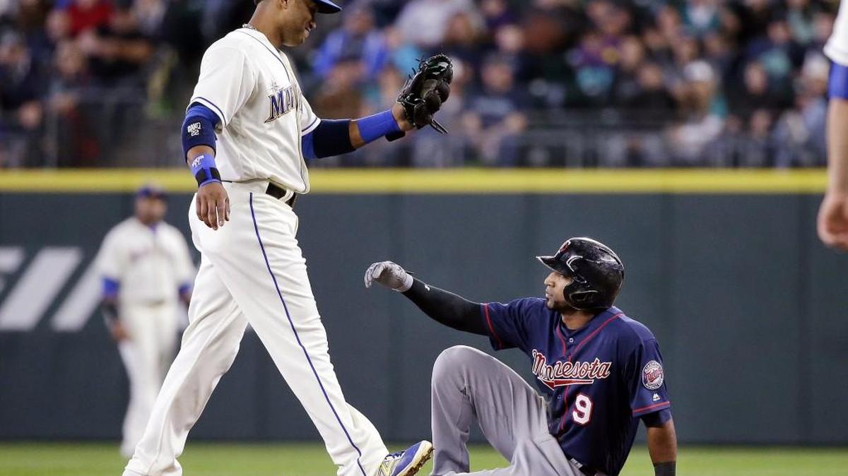 Minnesota Twins' Eduardo Nunez (9) sits and waits for Seattle Mariners second baseman Robinson Cano to tag him after Nunez slipped and fell after attempting to steal second base in the seventh inning of a baseball game Sunday, May 29, 2016, in Seattle.