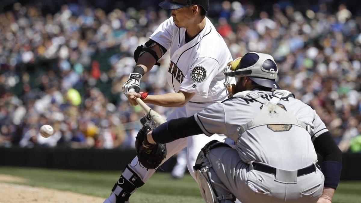 San Diego Padres catcher Derek Norris, right, interferes on a swing by Seattle Mariners’ Nori Aoki in the sixth inning of Monday’s game.