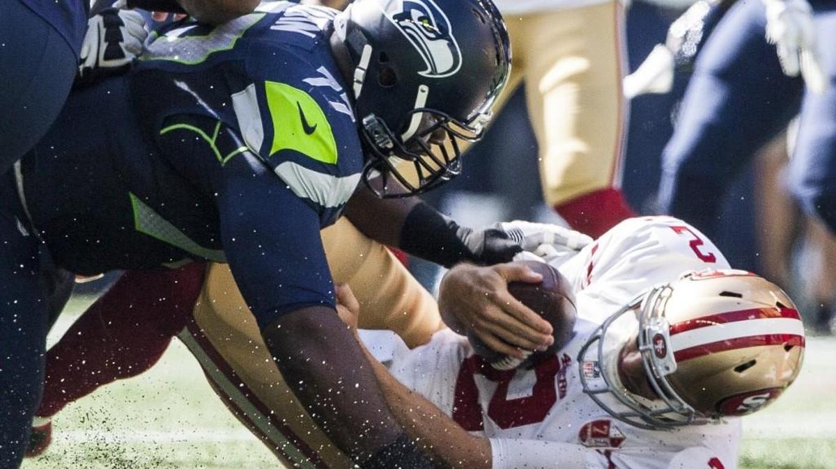 Seahawks defensive tackle Ahtyba Rubin (77) hits 49ers quarterback Blaine Gabbert (2) in the first quarter. Seattle’s defense held San Francisco’s offense to only three points for the first three quarters.