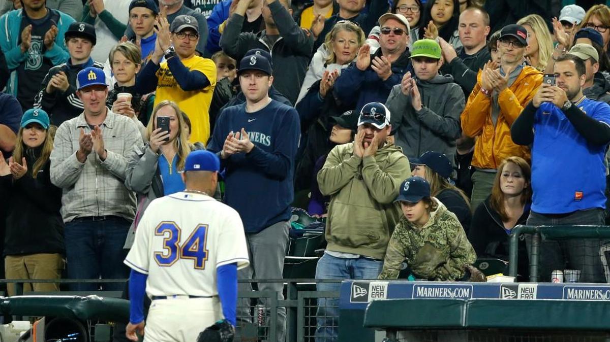 Fans cheer as Seattle Mariners starting pitcher Felix Hernandez (34) walks to the dugout Sunday after being pulled from a baseball game against the Los Angeles Angels in the eighth inning. Hernandez struck out nine, but allowed seven hits, and the Angels defeated the Mariners 3-0.
