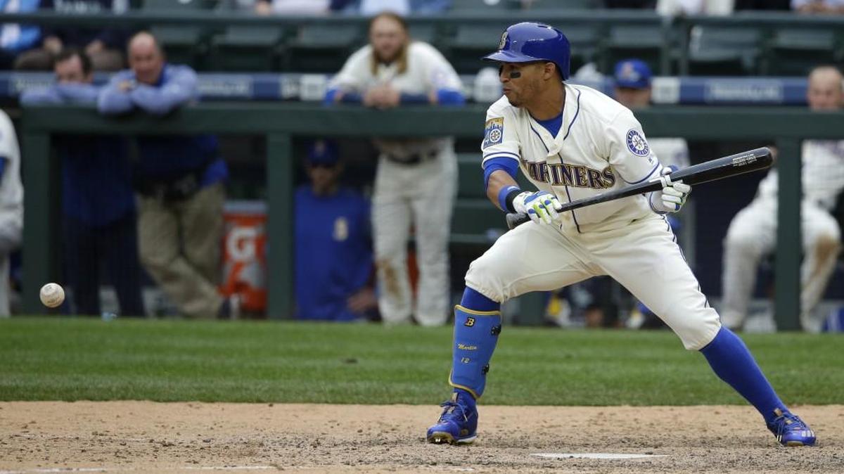 Seattle Mariners’ Leonys Martin hits a bunt single in the ninth inning against the Texas Rangers. Martin was designated for assignment on Sunday after only hitting .111 so far this season.